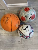 Basketball, Puma soccer ball, Nike soccer ball on floor