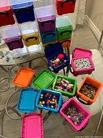 Open coloured storage boxes displaying assorted beads and embellishments