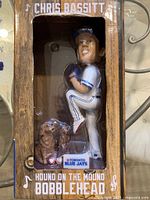 Front view of bobblehead in box showing figure, dog, base label