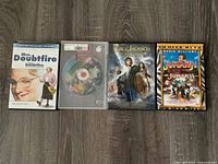 Front covers of four DVDs: Mrs. Doubtfire, Shrek 2 (disc), Percy Jackson, Jumanji