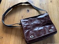 Front view of brown leather Texier briefcase with shoulder strap