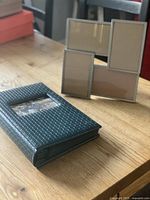 Album and frame together on table