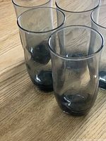 Five smoke-grey glasses on wooden surface, showing overall lot