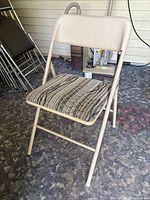 Beige Cosco folding chair showing overall frame and patterned padded seat