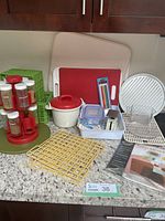 Collection of plastic kitchenware including cutting boards, spice rack, and other items on countertop