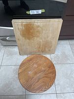 Photo showing both the round Lazy Susan and the square cutting board with visible wear and stains on the cutting board.