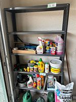Full view of the 5-tier metal shelf loaded with various household chemicals and garden products to show structure and usage.
