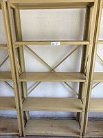 Full front view of 5 tier metal shelf showing five flat metal shelves and metal cross brace on back