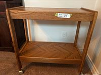 Side view of wooden rolling serving cart showing lower shelf and caster wheels