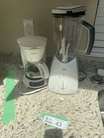 Mr. Coffee 4-cup coffee maker and Braun blender side by side on countertop.