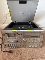 Full front view showing the front panel with cassette deck, buttons, equalizer sliders, volume and tuning knobs, 8-track slot, and AM/FM tuning scale.