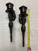 Full view of both sconces beside tape measure showing length