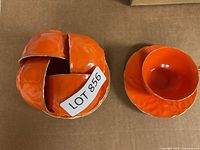 Stack of cups or saucers showing orange glaze and gilded rims