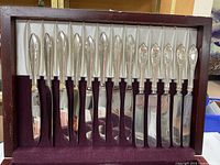Lid section showing 14 silverplate knives in two patterns