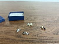 All four earring pairs and box on table