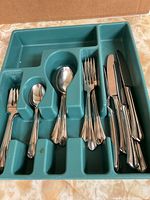 Overall view of flatware pieces in tray showing knives, forks and spoons