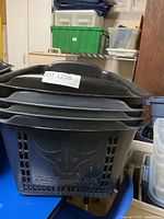 Stacked black plastic grocery baskets showing exterior shape and vented sides