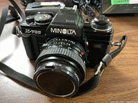 Front view of Minolta X-700 camera with attached 50 mm lens and strap
