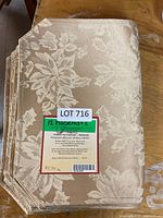 Stack of placemats with retail tag showing floral jacquard pattern