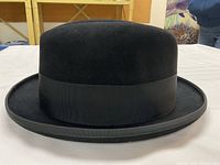 Side profile of black felt Stetson homburg with bound brim and ribbon band