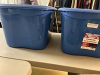 Two blue Tuff Store storage totes on table
