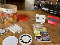 Tabletop view showing Gift Pak cylinder, lid, viewers, reel packets and loose reels