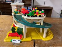 Front view of Fisher-Price garage showing elevator tower, ramp, cars and figures