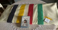 Folded Hudson's Bay blanket with book on top, showing stripes