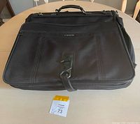 Closed Samsonite garment suitcase on table showing exterior and logo