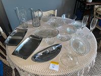 Entire lot on table showing stainless pieces and multiple pressed-glass items