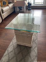 Square end table with glass top and travertine base