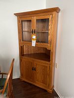 Full view of corner cabinet showing glass upper doors and wood lower doors