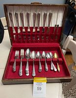 Overall view of open flatware case showing knives, handles in lid, forks and spoons in lower rack