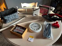 Overview of lot displaying both lunch bags, mop, puzzle chest, clock, insoles, Dirt Devil vacuum and accessory