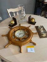 All items overview: ship’s wheel clock, globe bookends, etched hurricane glass, wood base with glass holders