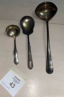 All three silver-plate utensils laid out for size comparison