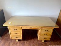 Front view of desk showing glass top, drawers and legs
