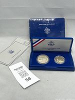 Two proof coins in protective capsules displayed in blue velvet case with original outer box and specification cards included.