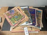 Stack of twelve colorful offset prints with diverse surreal and psychedelic themes by Mike Hartman.