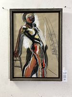 Framed expressionist nude figure study on paper showing full figure standing, head turned, arm resting on stool, with visible rustic wood-grain frame.