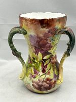 Front view of the vase showing the three branch-like handles and detailed floral painting