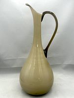 Front angle view of 15-inch Empoli glass ewer showing the smooth caramel colored body and applied handle.
