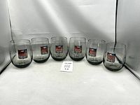 Set of six smoked glass tumblers with Penske Racing graphics arranged in a row.