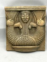 Front view of vintage cast plaster bas relief featuring stylized siren figure with fish tail, signed.