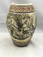 Front view of vintage Japanese stoneware vase displaying raised dragon motif and incised geometric border at top.