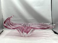 Front angled view showing sculptural pink and clear blown glass centerpiece with flared edges.