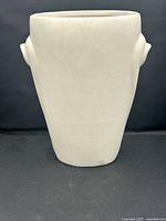 Front view of the ivory glazed pottery vase showing its form with raised sculptural handles and matte finish.