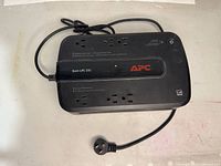 Top view of black APC Back-UPS 350 UPS unit with power cord and multiple outlets visible