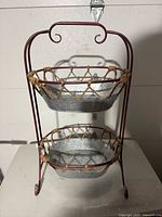 Two-tiered basket tray with galvanized metal baskets and reddish metal frame, viewed from front.