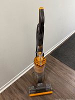 Front view of upright vacuum showing dust bin and cyclone assembly